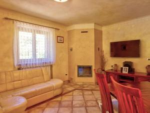 a living room with a couch and a television at Family Apartment Rihter in Črni Kal