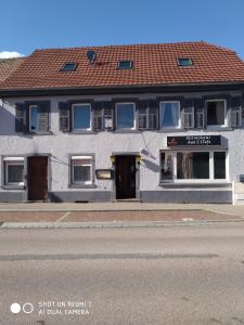 un edificio blanco al lado de una calle en Les Glycines, en Guewenheim