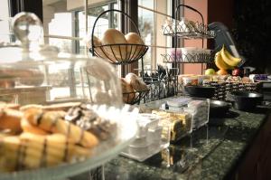 a buffet with pastries and other food on a counter at Belvedere Inn Schenectady - Albany in Schenectady
