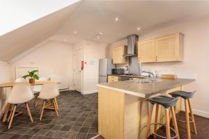 a kitchen with a counter and stools in a room at Elliot Suite No9 - Donnini Apartments in Ayr