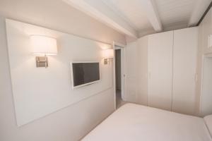 Habitación con cama y TV en la pared. en BILOCALE BELLA VISTA, en Temù