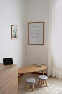 a wooden table and two stools in a room at Il Giusto bedandbreakfast in Lecce
