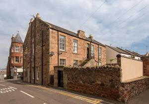 an old brick building on the side of a street at Stylish Beach Pad on Scotland's Golf Coast in North Berwick