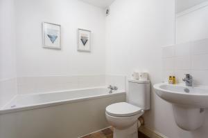 a white bathroom with a toilet and a sink at Elliot Suite No3 - Donnini Apartments in Ayr