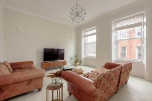 a living room with two couches and a flat screen tv at Stylish Beach Pad on Scotland's Golf Coast in North Berwick