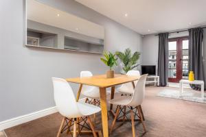 a dining room with a wooden table and white chairs at Elliot Suite No3 - Donnini Apartments in Ayr