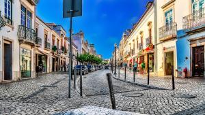 una calle adoquinada en una ciudad con edificios en Casa da Praia, Santa Luzia, en Tavira