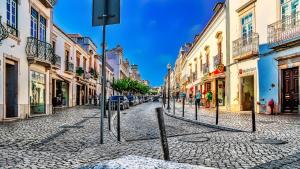 a cobblestone street in a city with buildings at Casa da Praia, Santa Luzia in Tavira