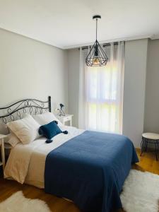 - une chambre avec un grand lit et une couverture bleue dans l'établissement Apartamento Rio San Isidro 2, à Felechosa