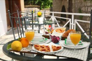 uma mesa com uma bandeja de comida e copos de sumo de laranja em La Magnolia Sorrento - City Centre Hotel em Sorrento