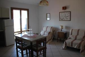 sala de estar con mesa y sofá en Casa Miclara - Bilocale "Limoni" en Zanca