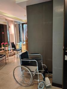 a wheelchair in a lobby with a table and chairs at Avatar Suites Hotel - SHA Extra Plus in Bangkok