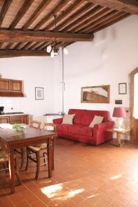 a living room with a red couch and a table at Agriturismo Escaia in Volterra +23 photos