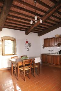 a kitchen with a table and chairs in a room at Agriturismo Escaia in Volterra