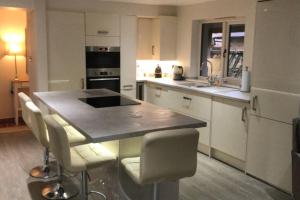 a kitchen with a large island with white cabinets at Barton Cottage in Bridgwater