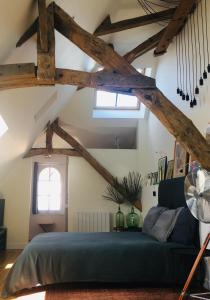 una camera con letto in una stanza con travi in legno di La Tour Bayeux a Bayeux