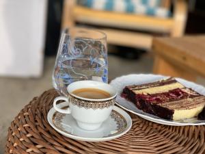 uma chávena de café e um pedaço de bolo numa mesa em Casa Dea em Gladna Montană