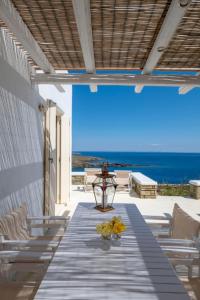 a table with chairs and a view of the ocean at Astrini in Kithnos