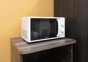 a microwave sitting on top of a wooden shelf at APA Hotel Namba Shinsaibashi Nishi in Osaka