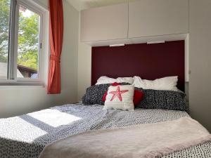 een slaapkamer met een bed met een rood hoofdeinde bij Bungalow Lido in Colico