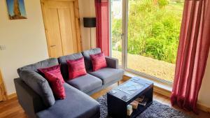 a living room with a couch and a window at Uig Chalets Idrigill Hill Chalet in Uig