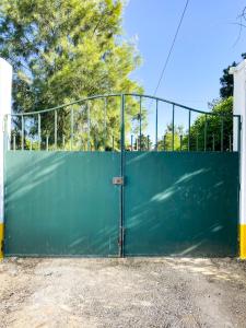 a green gate in front of a building at São Cristóvão Farmhouse Setúbal in Setúbal