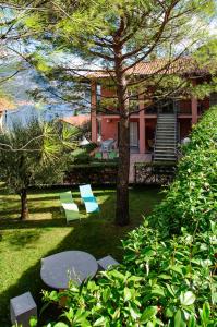 a yard with two chairs and a tree and a house at Ca' Eli 2 in Oliveto Lario