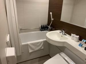 a bathroom with a sink and a toilet and a tub at Roppongi Plaza Hotel in Tokyo