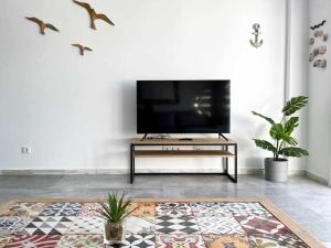a living room with a flat screen tv on a tv stand at Tarifa Beach Rentals Sunset in Tarifa