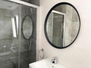 a bathroom with a mirror and a sink and a shower at Tarifa Beach Rentals Sunset in Tarifa +34 photos