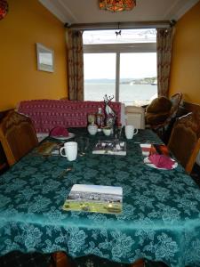 un tavolo con una tovaglia verde e una vista sull'oceano di Sunnyside House a Rothesay