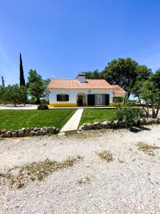 a small yellow house with a gravel driveway at São Cristóvão Farmhouse Setúbal in Setúbal