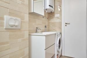 a bathroom with a sink and a washing machine at Apartments Nika in Turanj