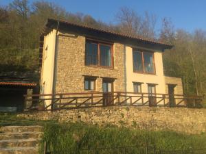 une maison en pierre au-dessus d'un mur en pierre dans l'établissement RESIDENZA CIMA LE VIGNE, à Millesimo