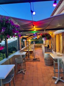 an outdoor patio with tables and chairs and aventh at Relais de Saleccia in Casta