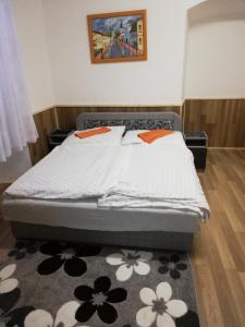 - un lit dans une petite chambre avec un tapis dans l'établissement Arany Bárány Vendégfogadó, à Letenye