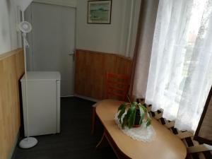 a room with a table with a plant on it at Arany Bárány Vendégfogadó in Letenye