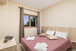 a bedroom with a bed with two towels on it at Poseidon Apartments in Kissamos