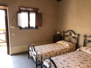 une chambre avec deux lits et une fenêtre dans l'établissement RESIDENZA CIMA LE VIGNE, à Millesimo