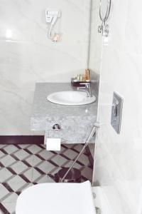 Baño blanco con lavabo y aseo en Oriental Residence, en Dammam