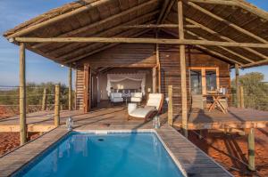 uma casa com uma piscina e um deque de madeira em Bagatelle Kalahari Game Ranch em Hardap