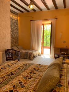a bedroom with two beds and a window at Hotel rural La soleia d'Oix in Oix