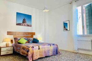 a bedroom with a bed and a large window at chiesa dei madonna orto room in Venice
