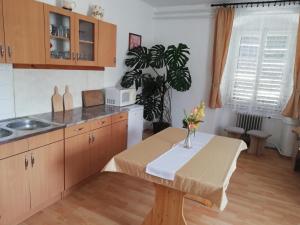 a kitchen with a table with a vase of flowers on it at Arany Bárány Vendégfogadó in Letenye