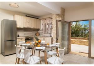 a kitchen with a table and chairs and a refrigerator at Poseidon Apartments in Kissamos +29 photos