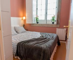 a small bedroom with a bed and two windows at Oporto Center Clean & Cozy Apt 3 in Porto