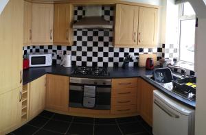a kitchen with a black and white checkered wall at The Gateway Guest Apartment in Portstewart +2 photos