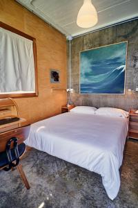 a bedroom with a bed and a desk and a window at Apartamento con piscina y excelentes vistas in Ferrol