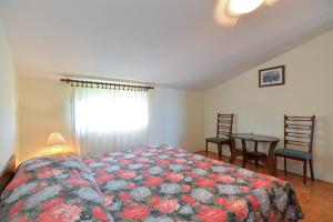 1 dormitorio con 1 cama, mesa y sillas en Apartment Andela 250, en Fažana