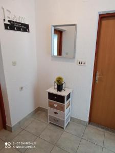 a small dresser with a plant on top of it in a room at Apartment LIKA in Gospić